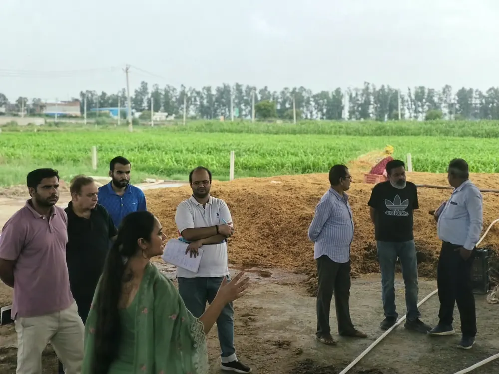 Trainees gathered at a straw pile while compost preparation is explained