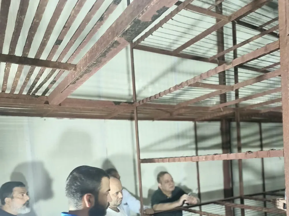 Visitors inspecting the tiered steel racks inside a mushroom growing room